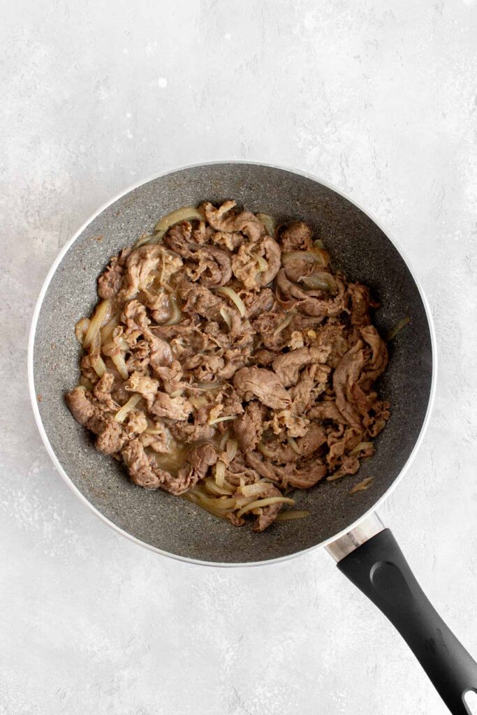 Sauce cooked down in a skillet of beef and onions.