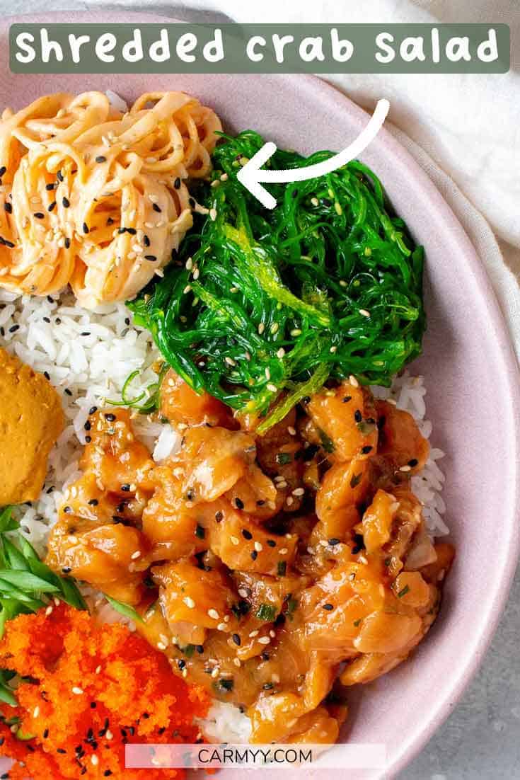 shredded crab salad being pointed to in a poke bowl.