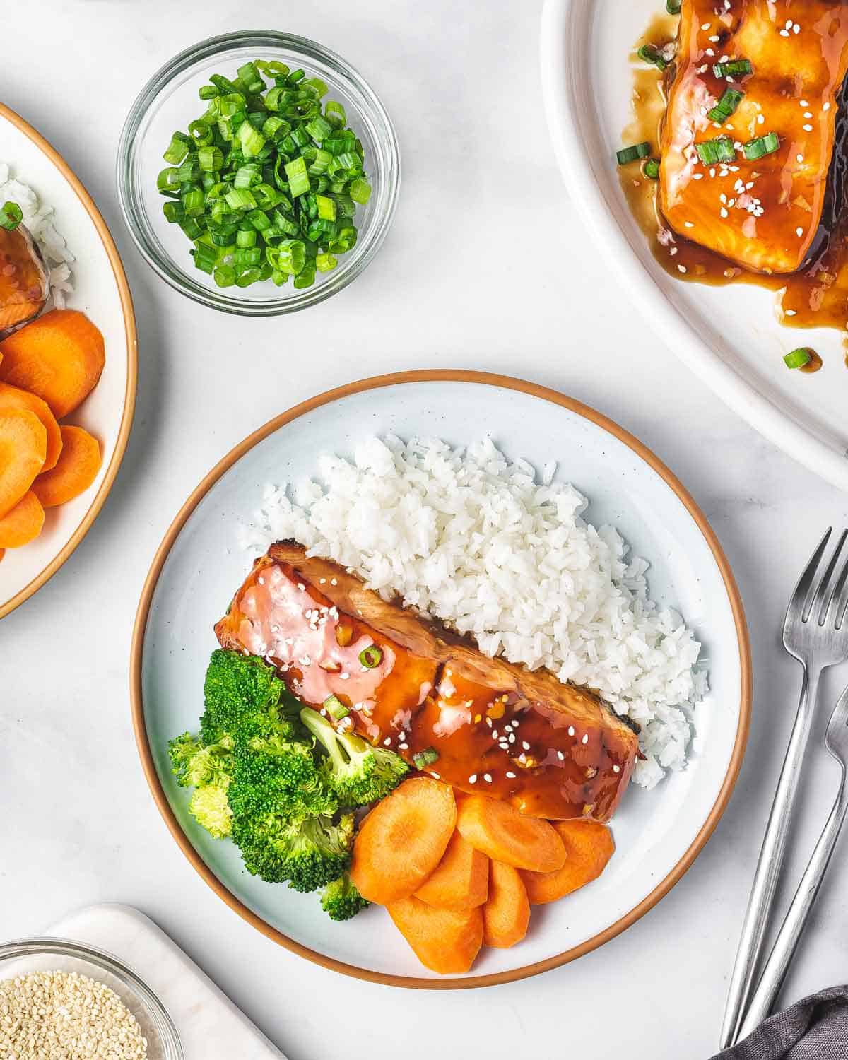 A plate of rice, air fryer teriyaki salmon, broccoli, and carrots.