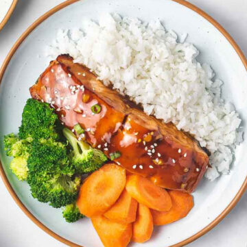 A plate of rice, air fryer teriyaki salmon, broccoli, and carrots.
