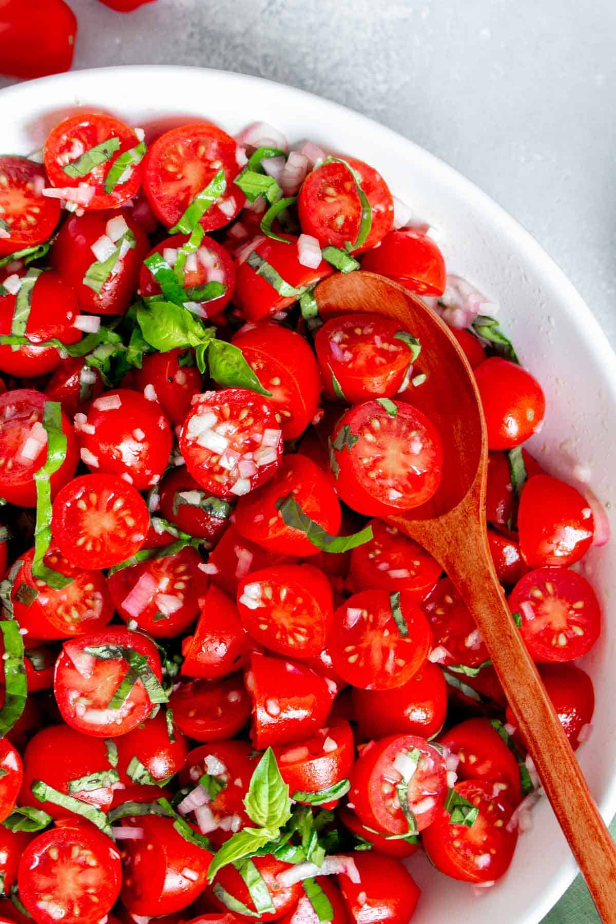Close up of a spoonful of marinated tomatoes.