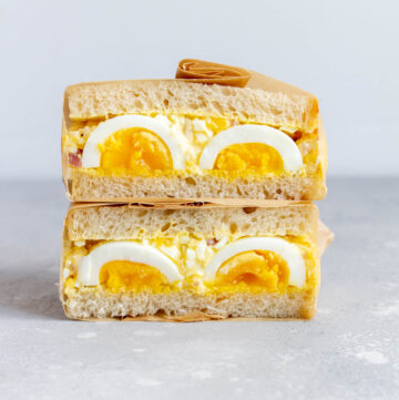Two halves of an egg sandwich stacked on top of each other.
