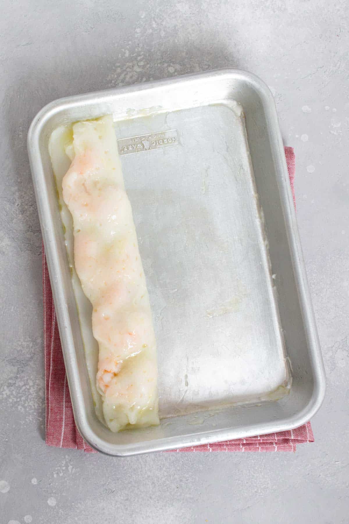 Cheung fun rolled up in a sheet pan.