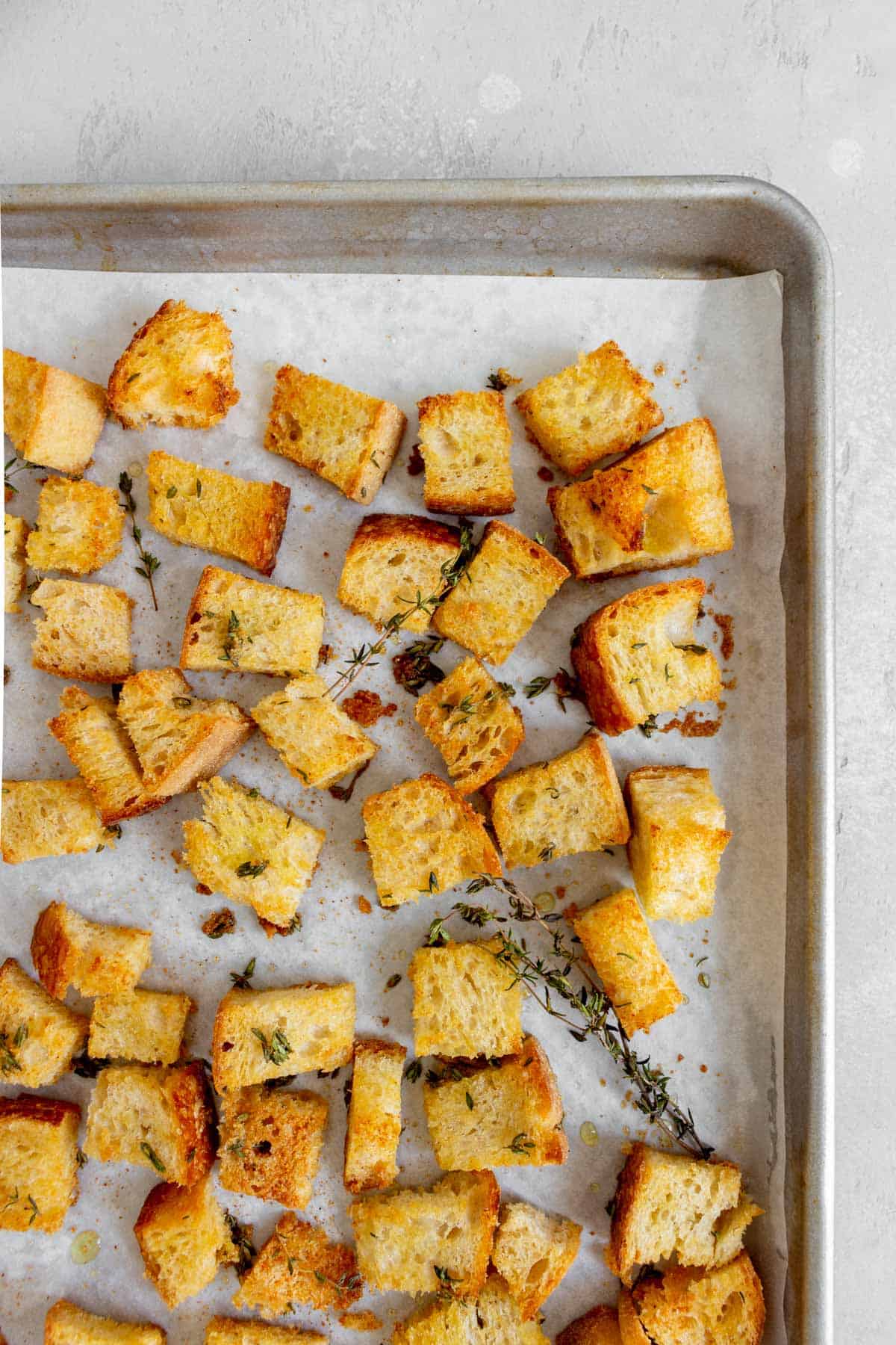Overhead view of sourdough croutons on a sheet pan.