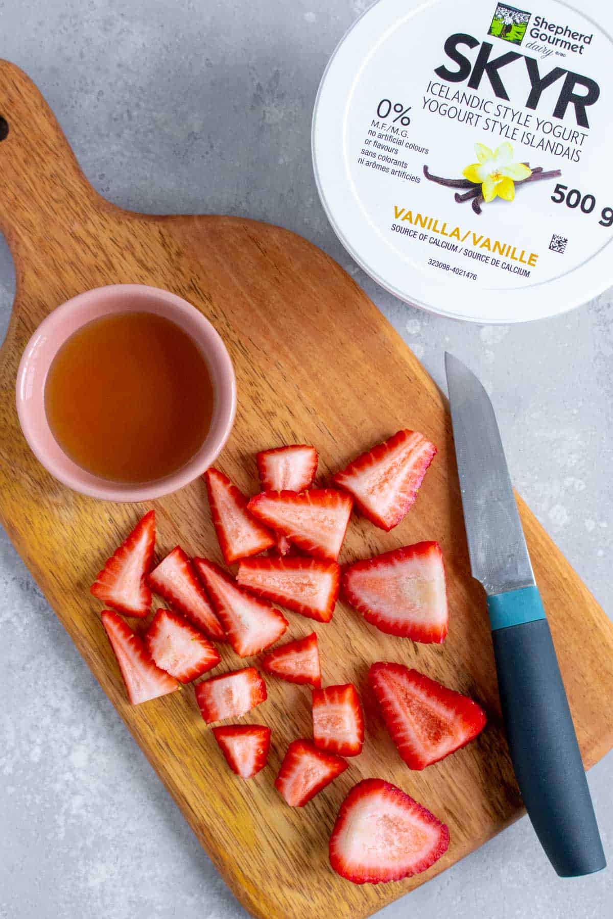 Ingredients needed to make frozen strawberry yogurt cubes.