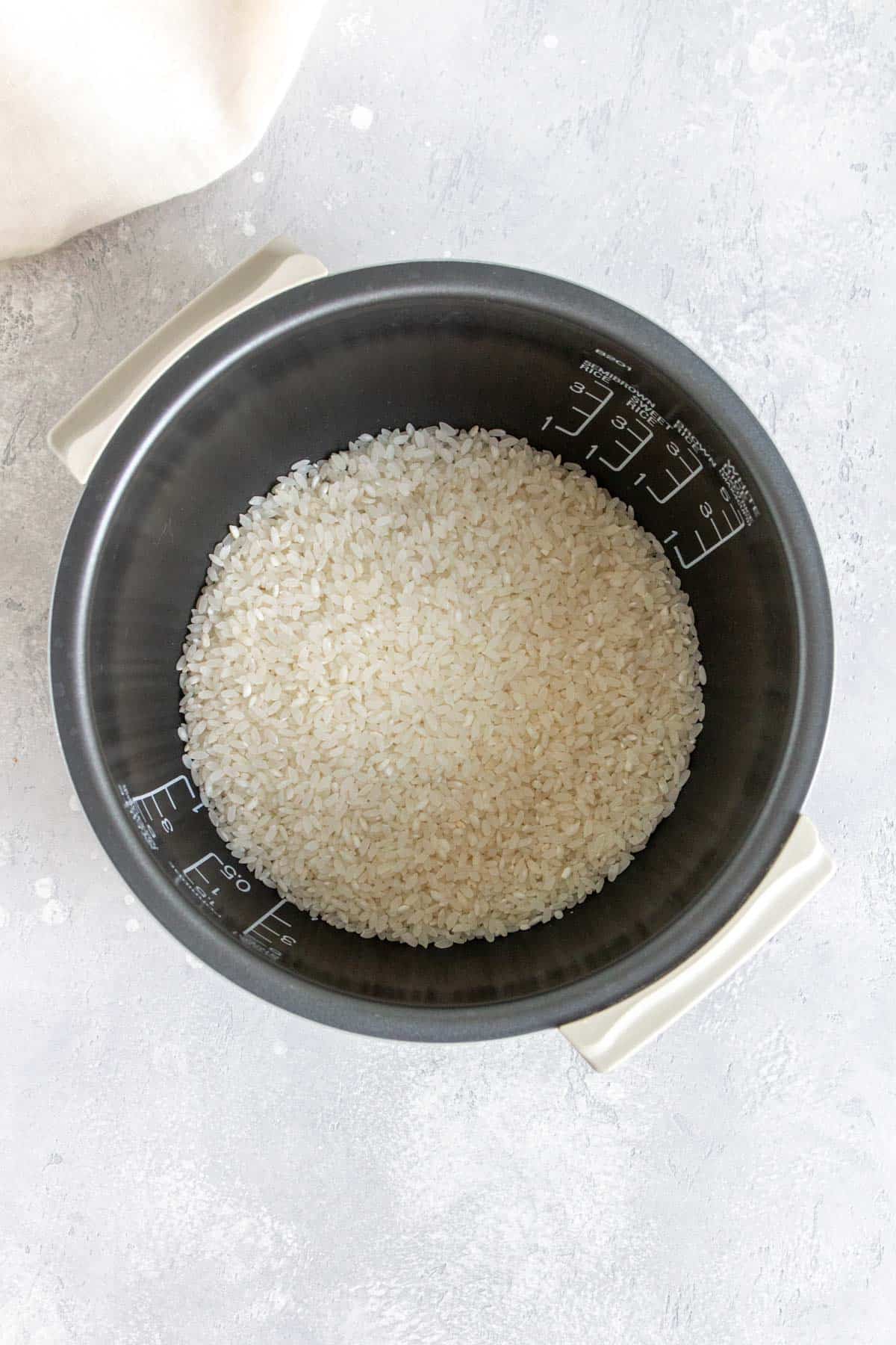 Uncooked rice in a rice cooker.