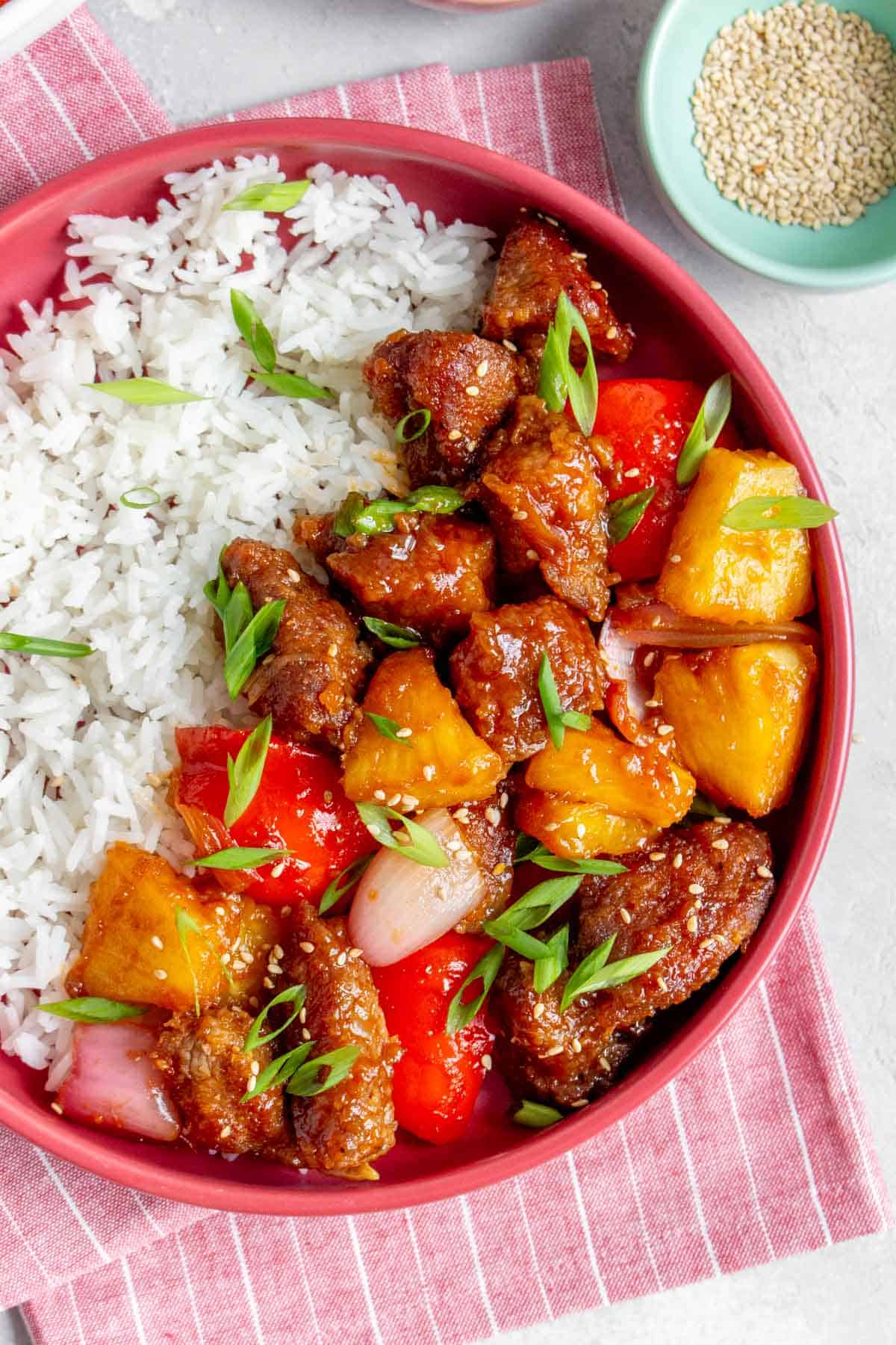 Close up of a plate with rice and sweet and sour pork.