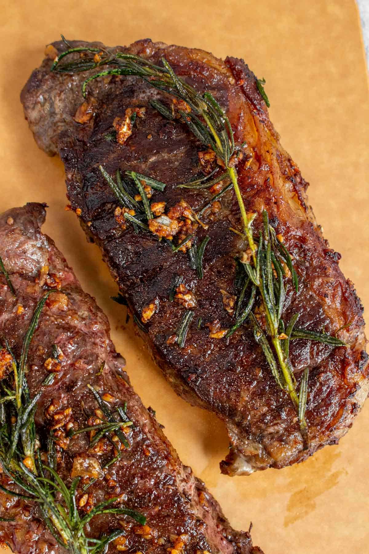 Overhead view of garlic butter steak with rosemary.