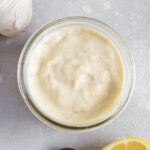 Overhead view of a jar of roasted garlic aioli.