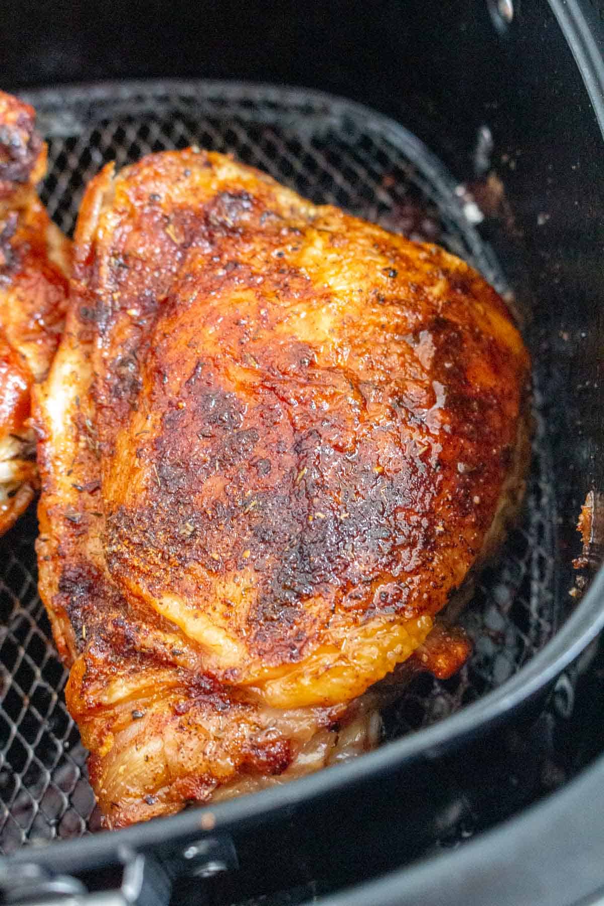 An air fryer turkey thigh in an air fryer basket.