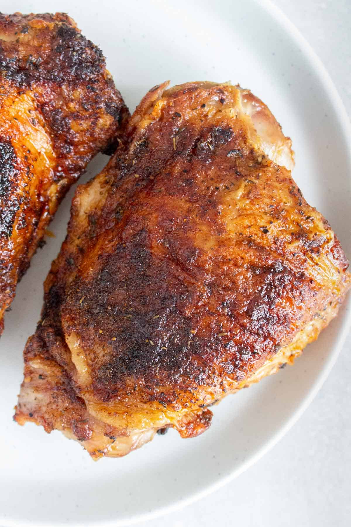 Air fryer turkey thighs on a white plate.