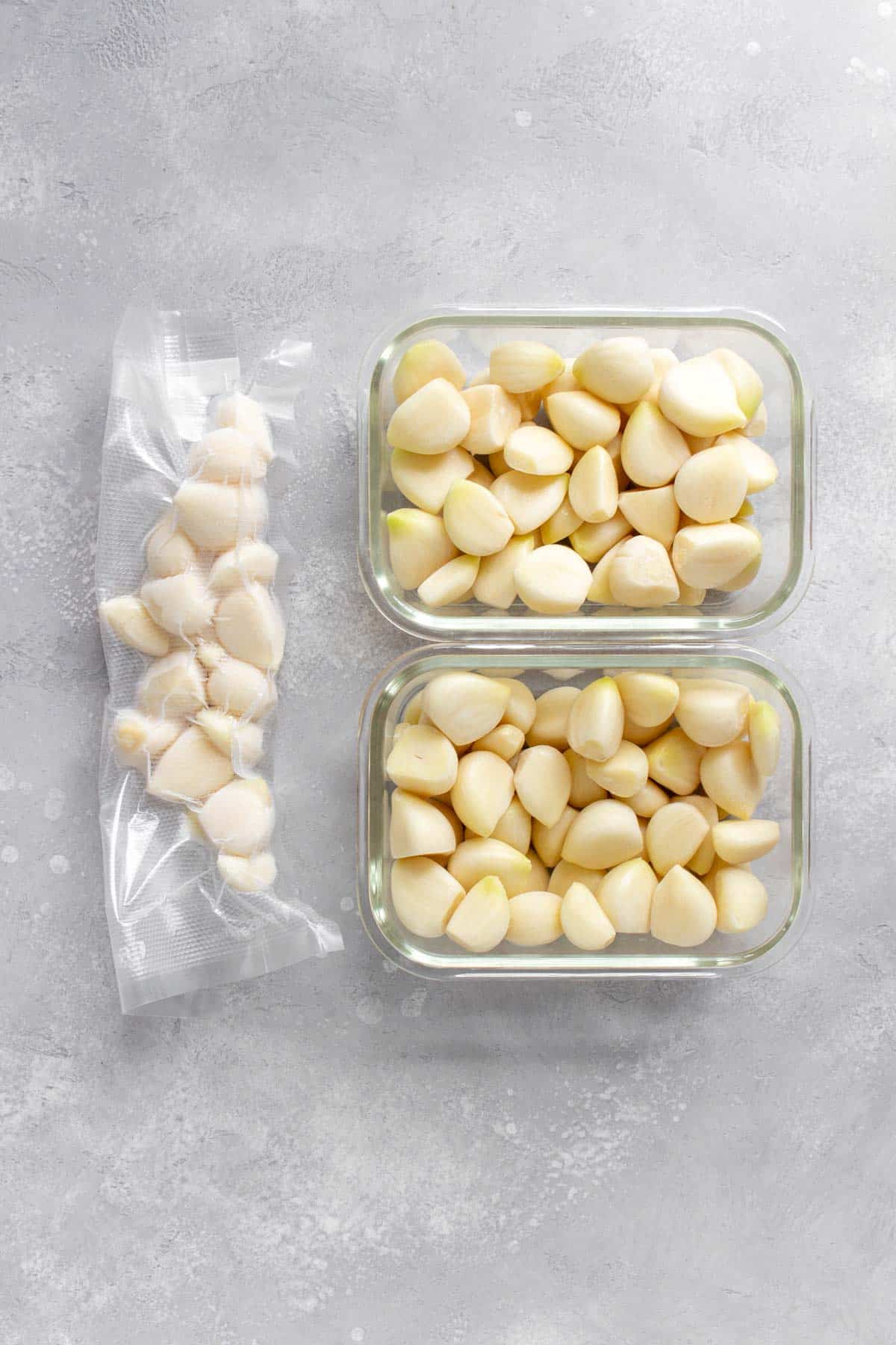 Frozen garlic cloves in two containers and some vacuum sealed.