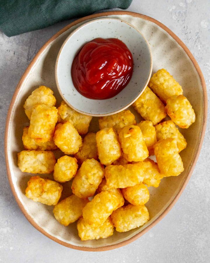 A platter of air fryer tater tots with a side of ketchup.