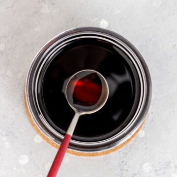 Overhead view of a jar of brown sugar syrup with a spoonful lifted out.