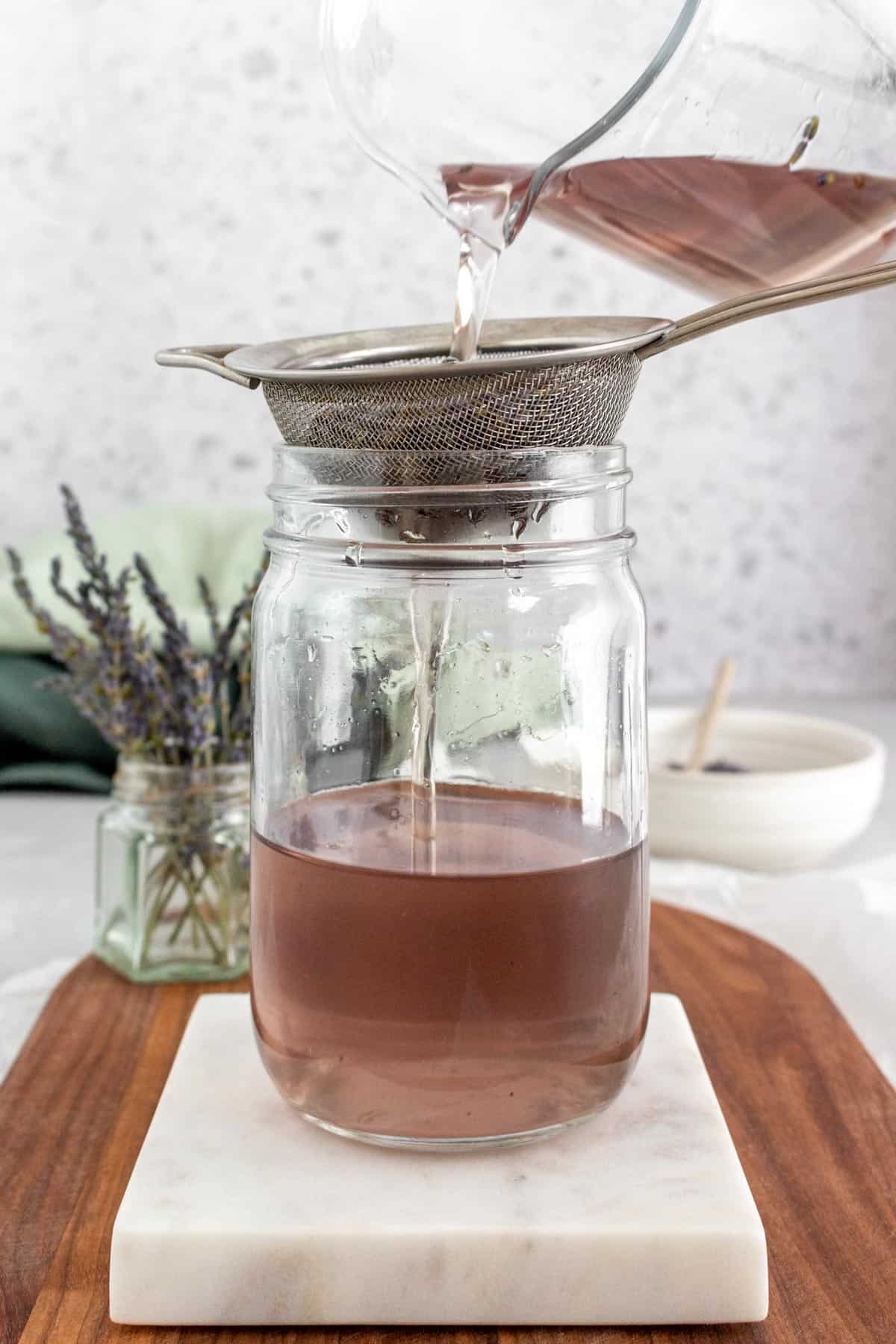 Lavender simple syrup strained into a mason jar.