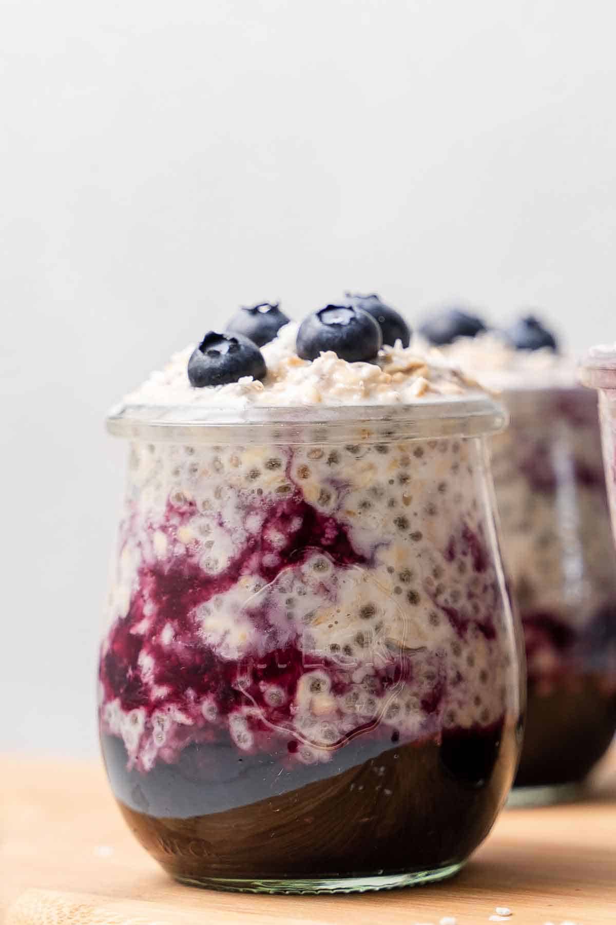 A jar of blueberry overnight oats with fresh blueberries on top.
