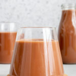Close up of a glass of chocolate oat milk on a stack of coasters.