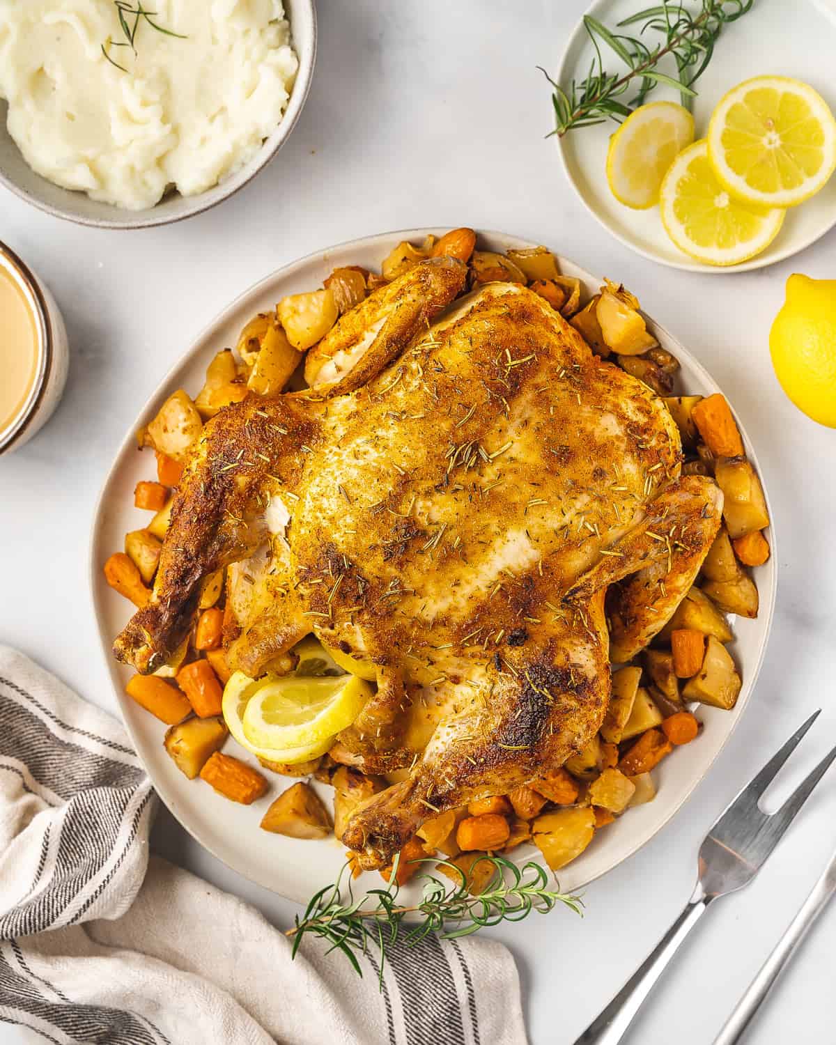 A slow cooker chicken over potatoes on a platter.