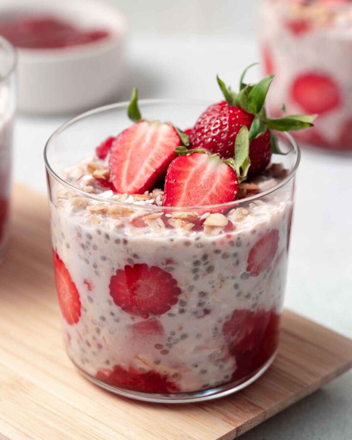 A jar of strawberry shortcake overnight oats with strawberries on top.
