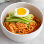 A bowl of bibim guksu with another bowl in the background.