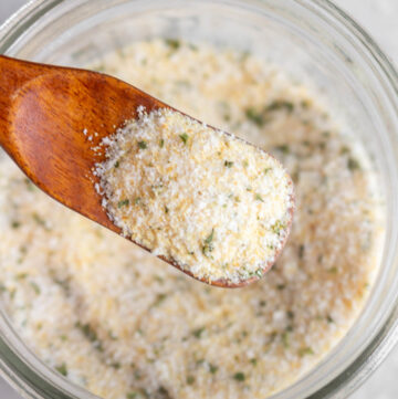 A spoonful of garlic salt lifted from the bowl.