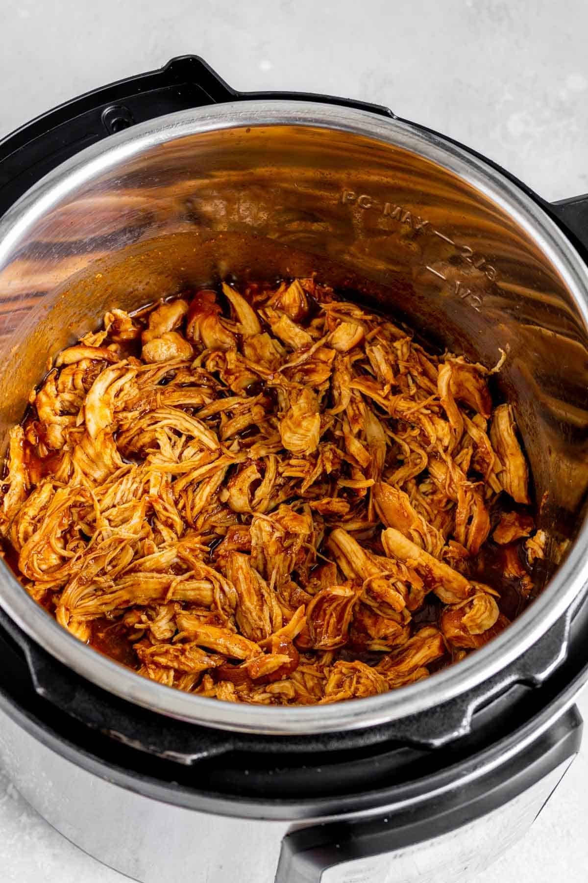 Shredded instant pot bbq chicken in the pressure cooker.
