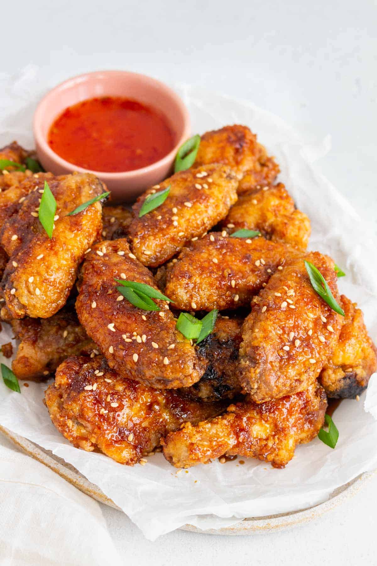 Angled view of a platter of soy garlic chicken wings.