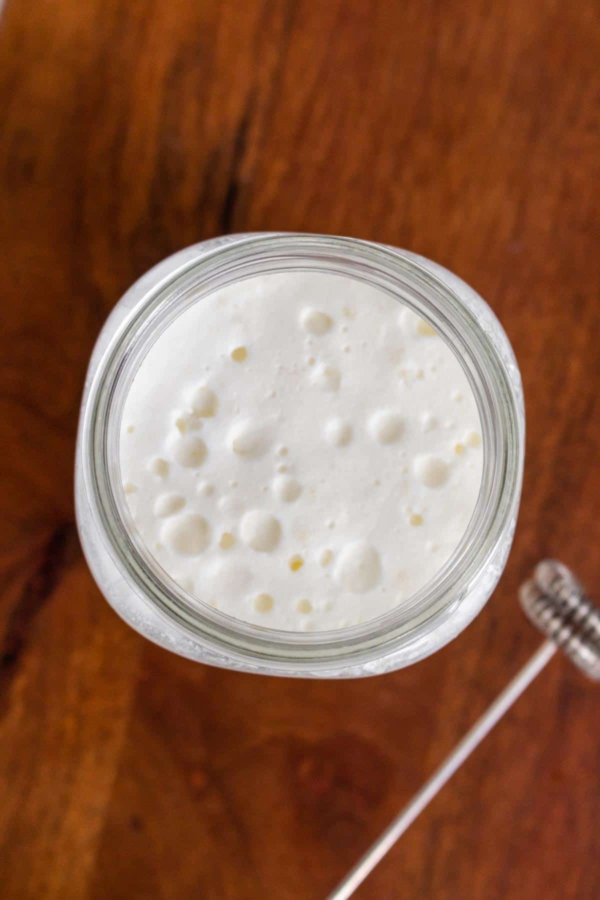 Overhead view of sweet cream cold foam in a mason jar.
