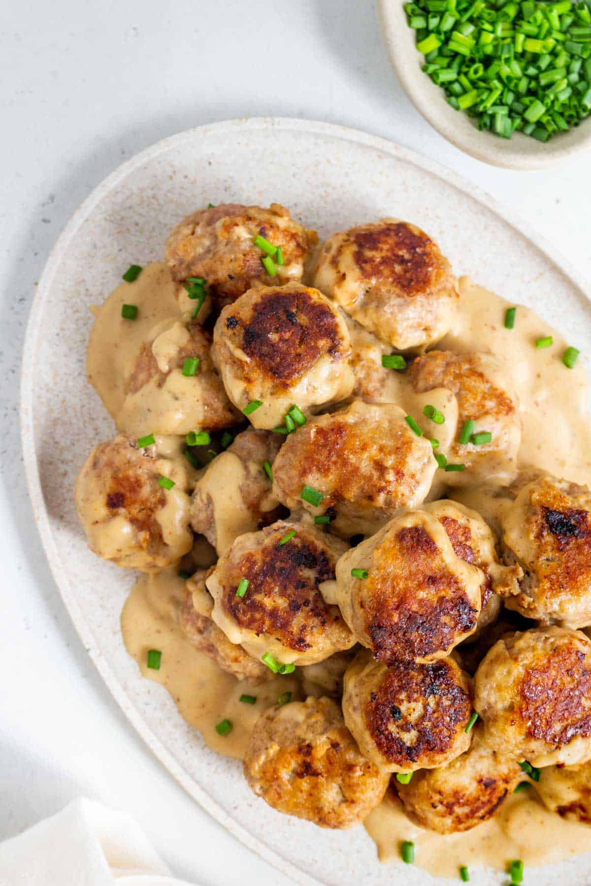 Close up view of an oval platter of turkey Swedish meatballs.