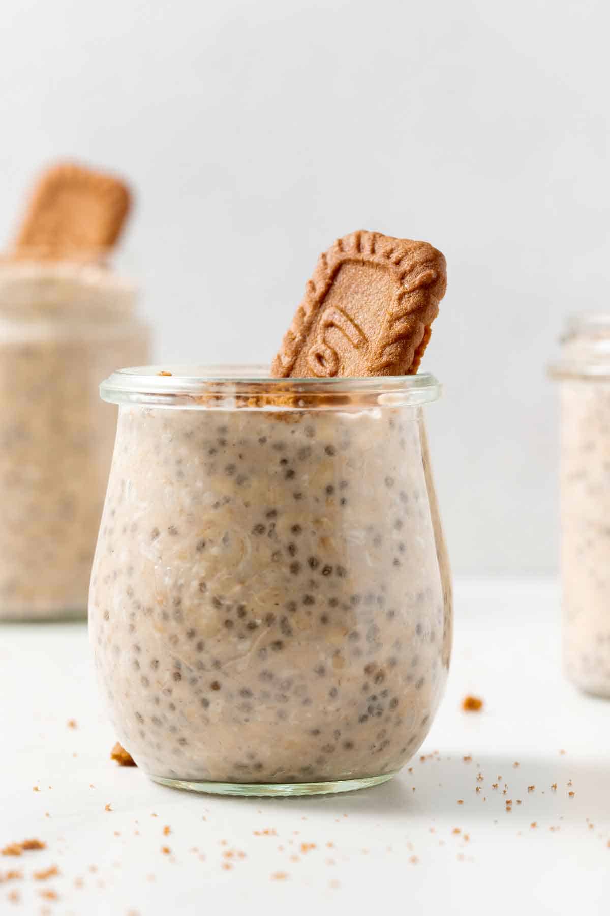 A jar of biscoff overnight oats with biscoff cookies crumbs and cookie.