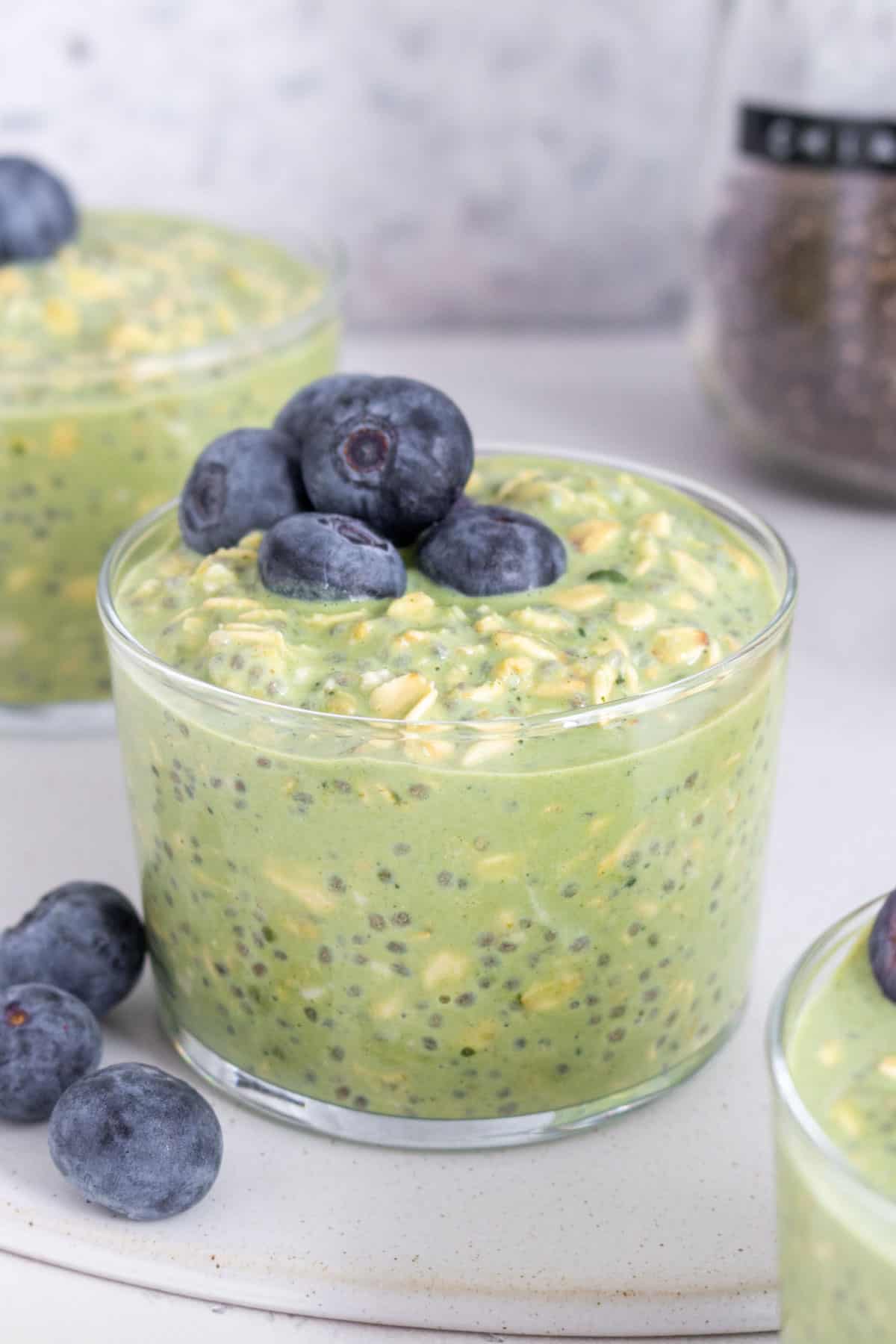 A jar of matcha overnight oats topped with blueberries.