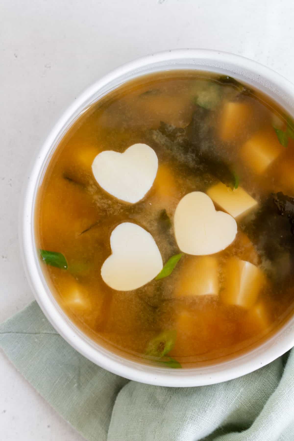Overhead view of miso soup with pieces of tofu floating.