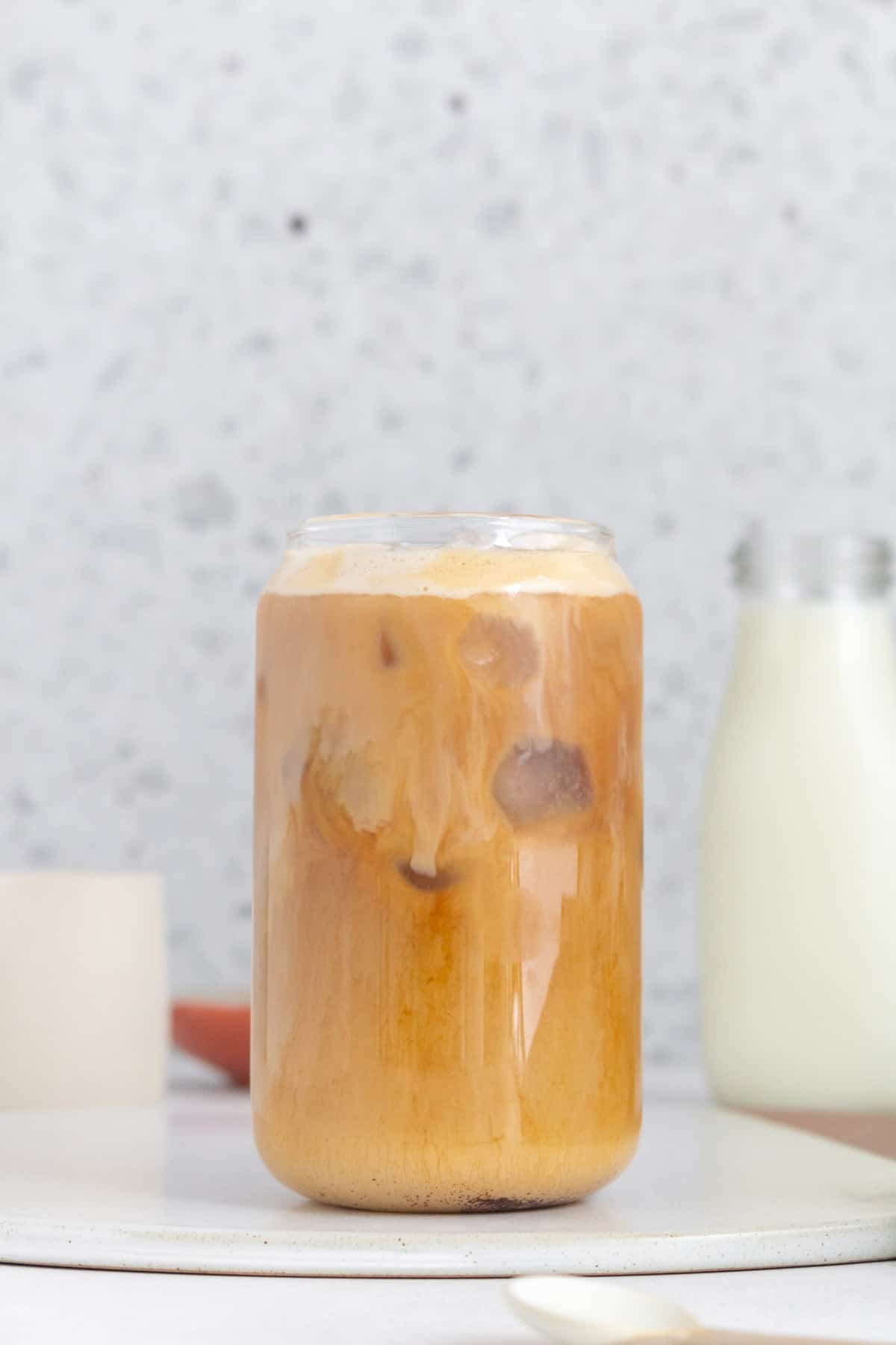 A glass of vanilla bean latte with ice.