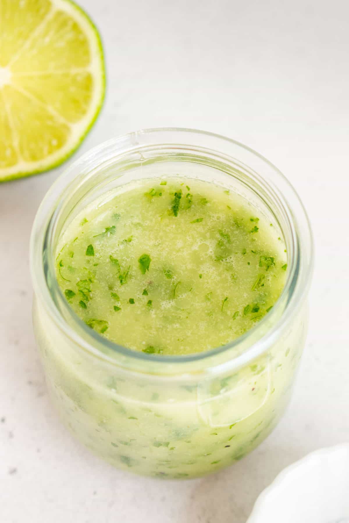 A slightly overhead angle of a jar of cilantro lime vinaigrette.