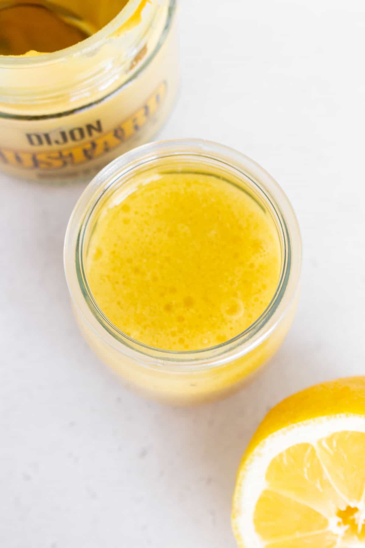 An overhead view of a jar of lemon honey dijon vinaigrette.