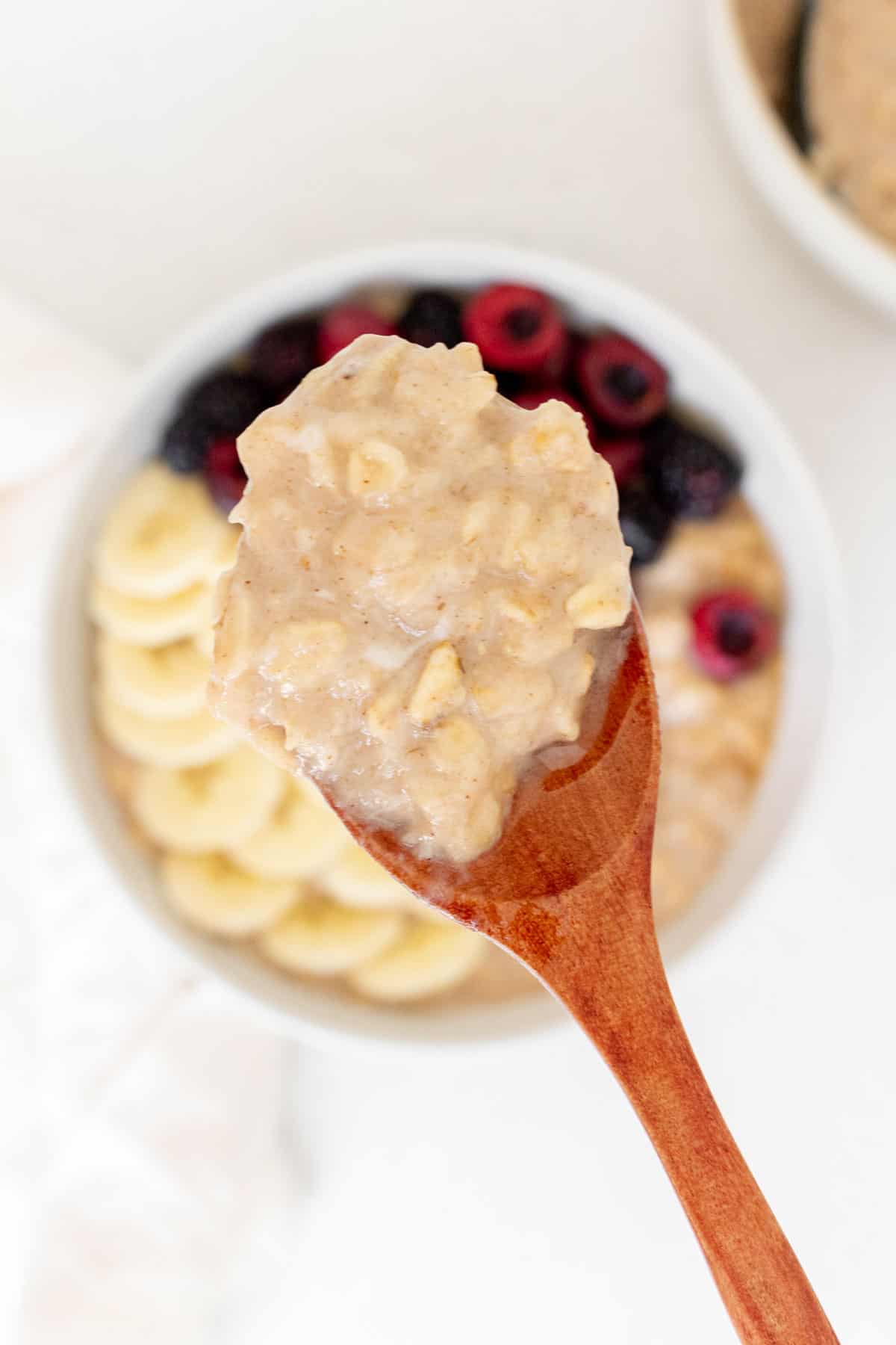 A spoonful of egg white oatmeal lifted from a bowl.