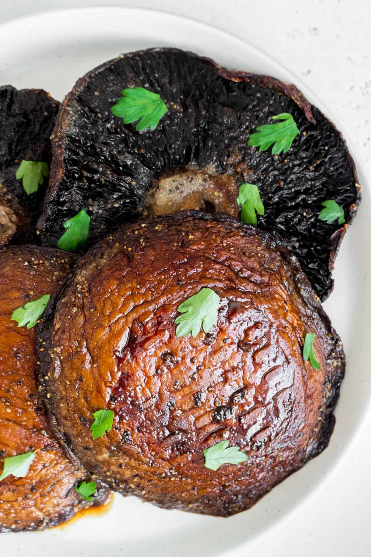 Overhead view of a plate with air fryer portobello mushrooms with parsley on top.