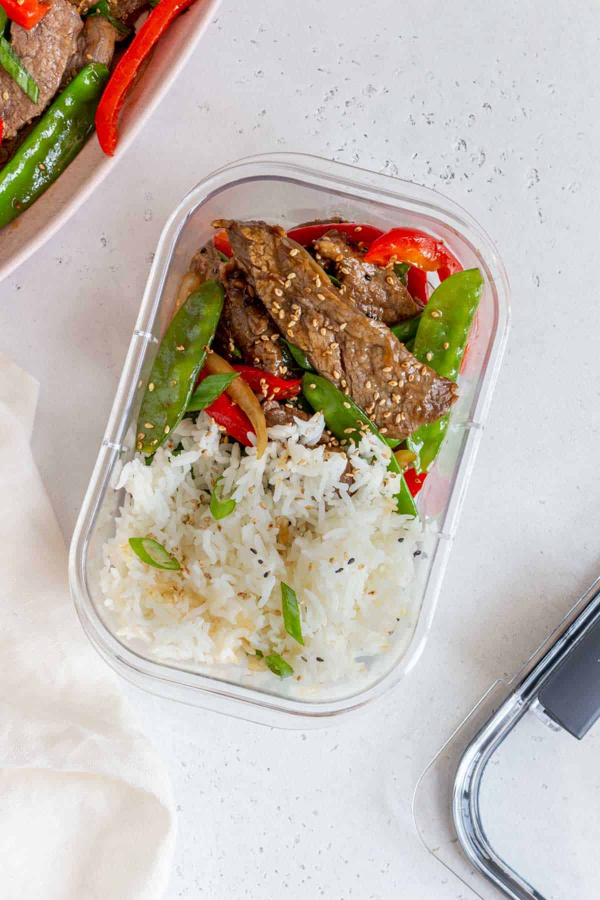 Overhead view of beef with oyster sauce and rice in a meal prep container.