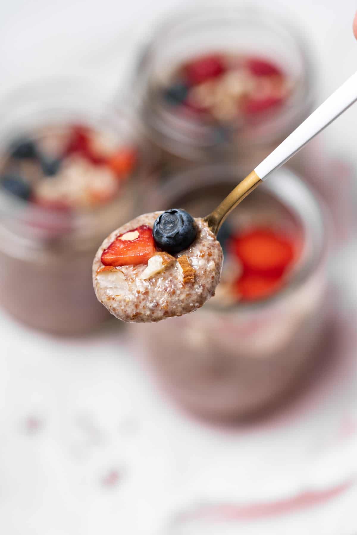 A spoonful of flaxseed pudding with chopped nuts and fruit.