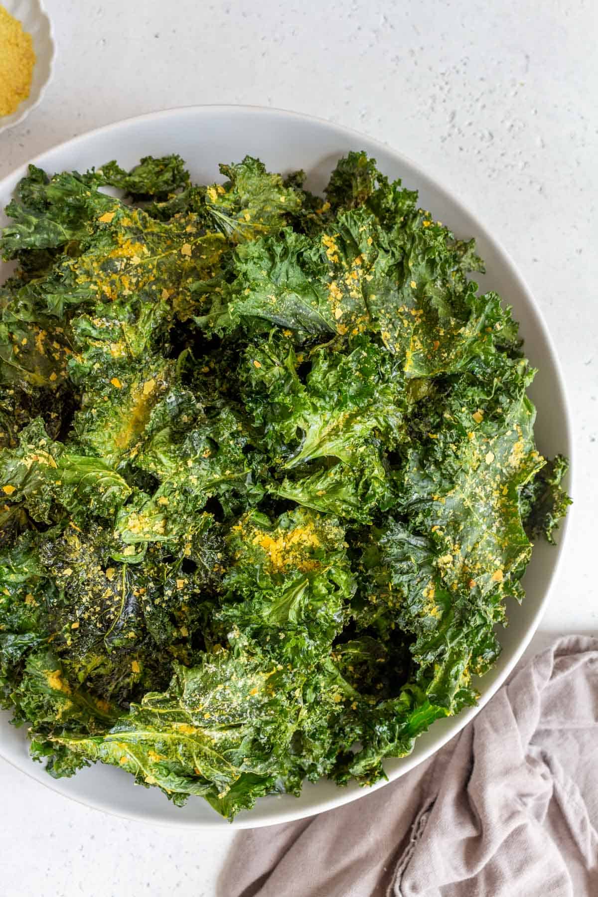 A bowl of kale chips with nutritional yeast.