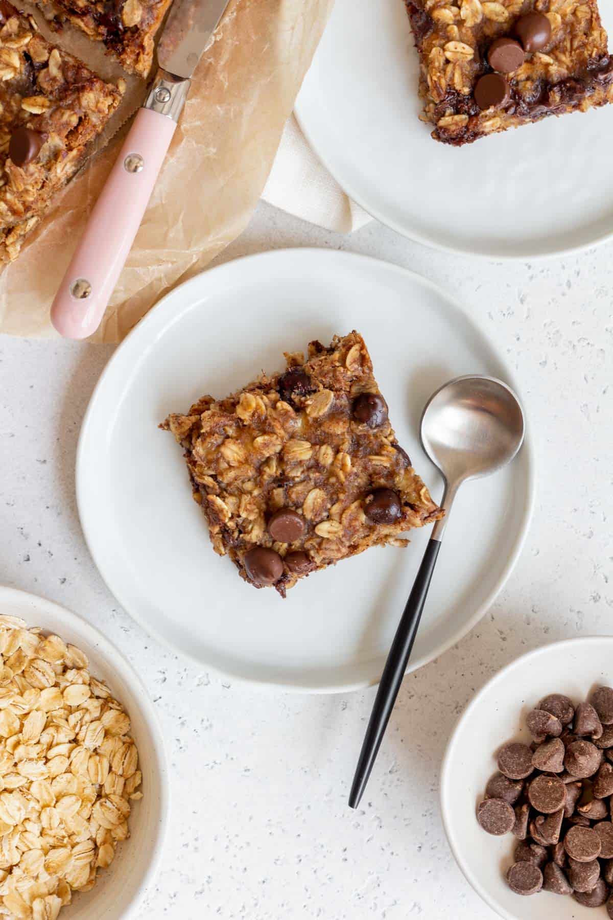 Overhead view of a banana oatmeal bar on a plate with a spoon.