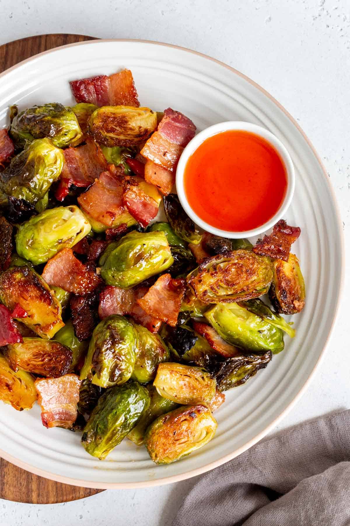 A plate of roasted brussels sprouts with bacon and hot honey.