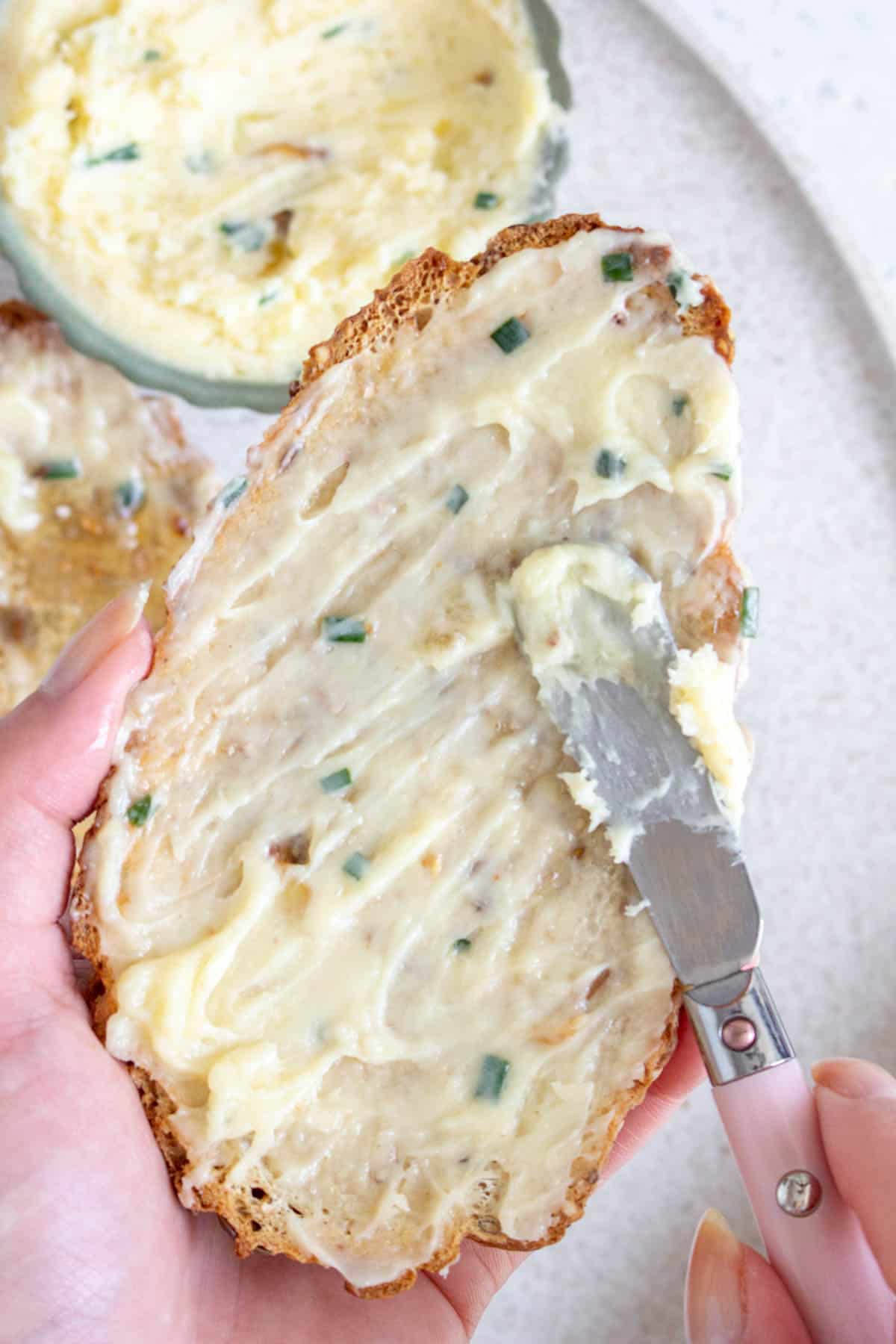 Roasted garlic butter spread onto a piece of toast.