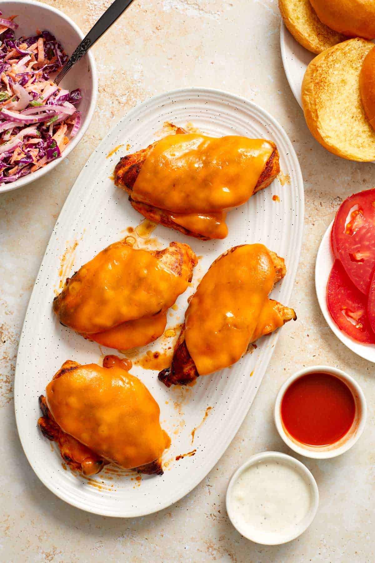 Overhead view of a platter of grilled buffalo chicken with melted cheese on top.