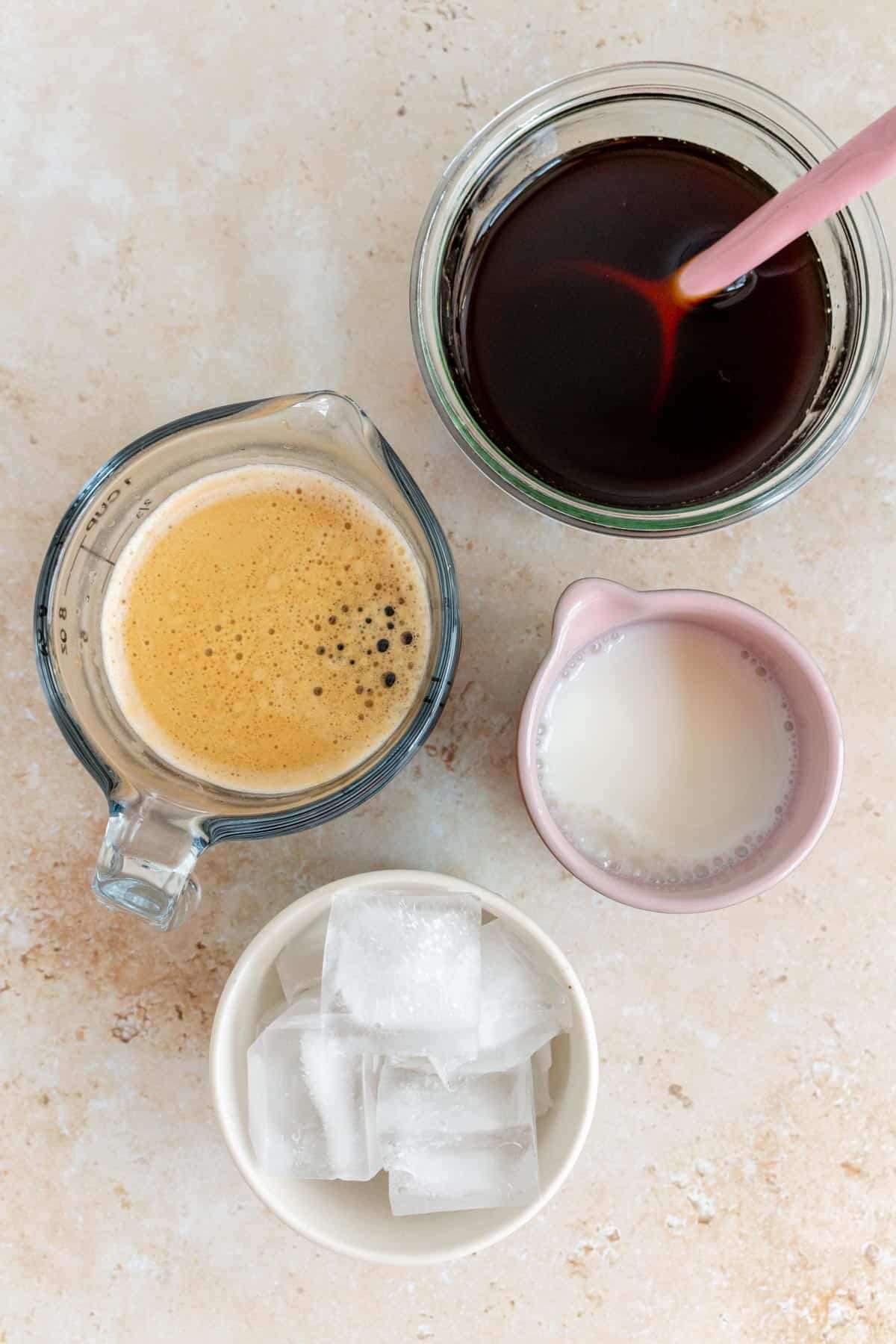 Ingredients needed to make an iced apple crisp oat milk shaken espresso.