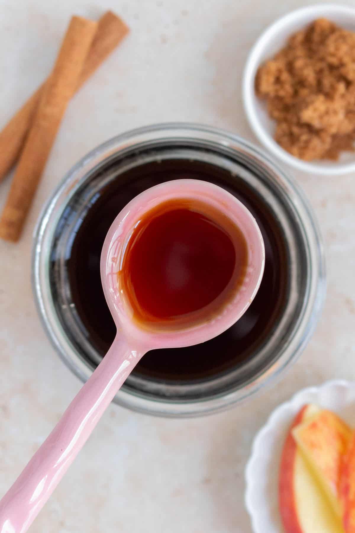 Overhead view of a spoonful of apple brown sugar syrup.
