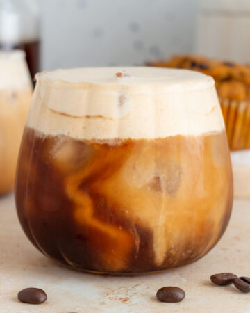 A cup of iced cold brew with pumpkin cold foam on top.