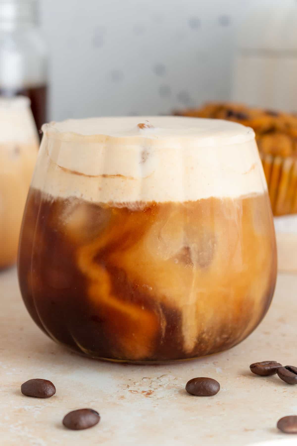 A cup of iced cold brew with pumpkin cold foam on top.
