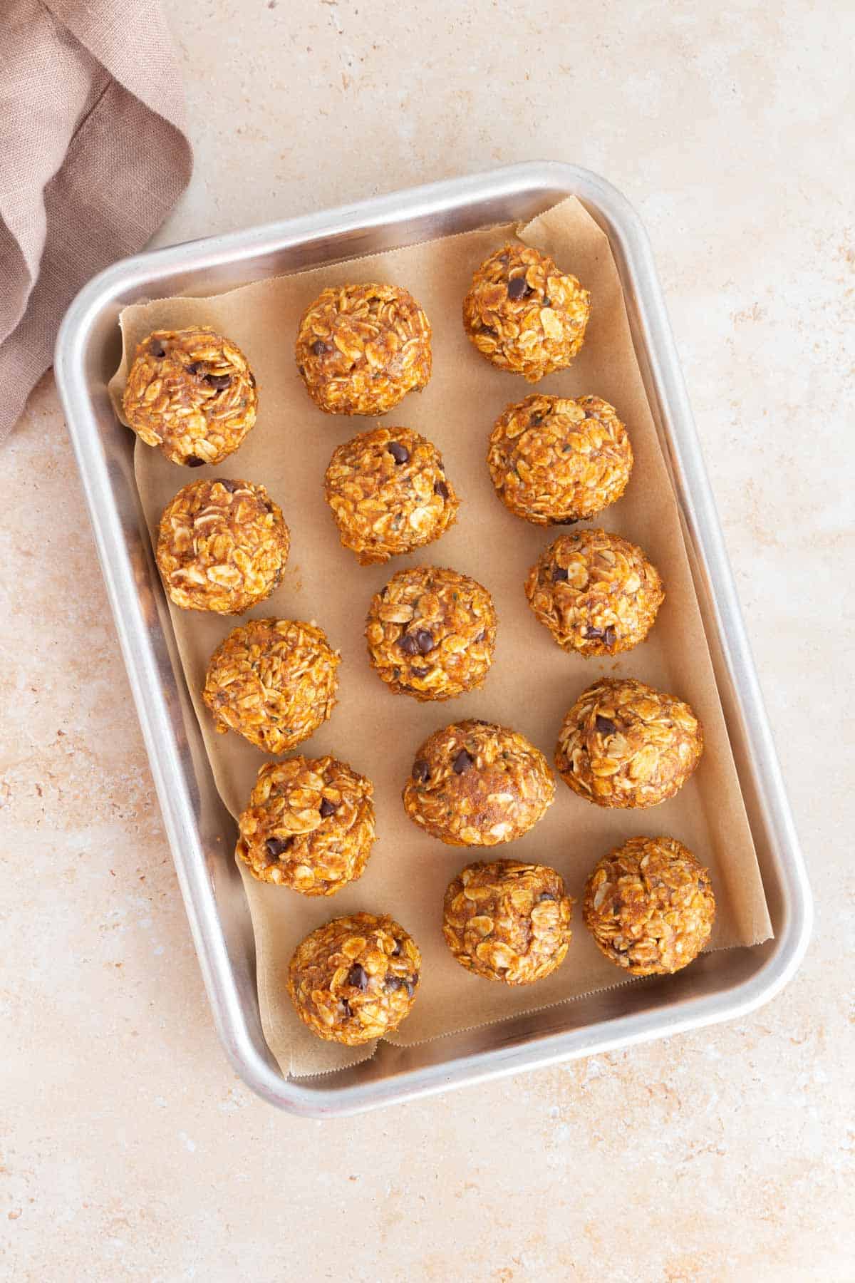 A lined sheet pan with pumpkin protein balls.