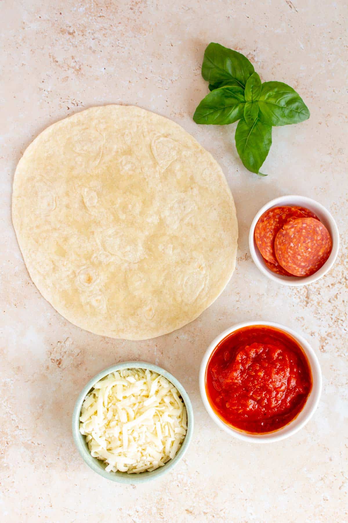 Ingredients needed to make an air fryer tortilla pizza.